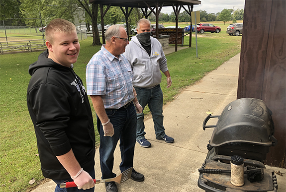 Austin Krueger, his grandfather Gene Krueger, and Neal Krause enjoyed Rally Day with a cook out.