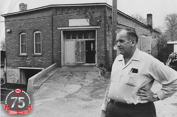 Ted Bachhuber stands in front of the original manufacturing facility.